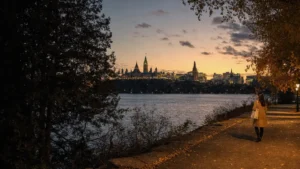 French Express Entry draw: woman on the Ottawa riverfront at dusk